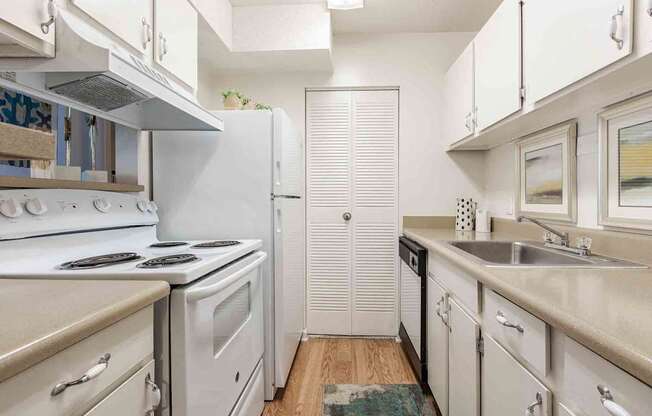 A kitchen with white appliances and cabinets.