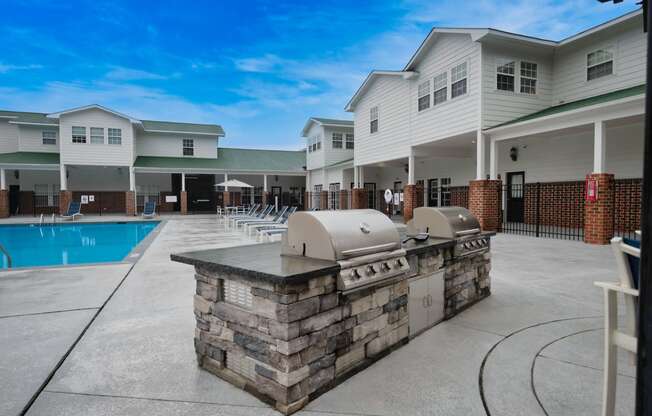 a patio with a grill and a pool in front of a building