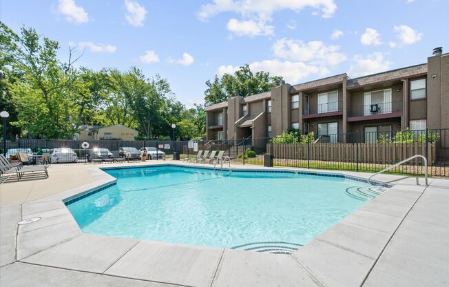 A swimming pool in front of apartment buildings.