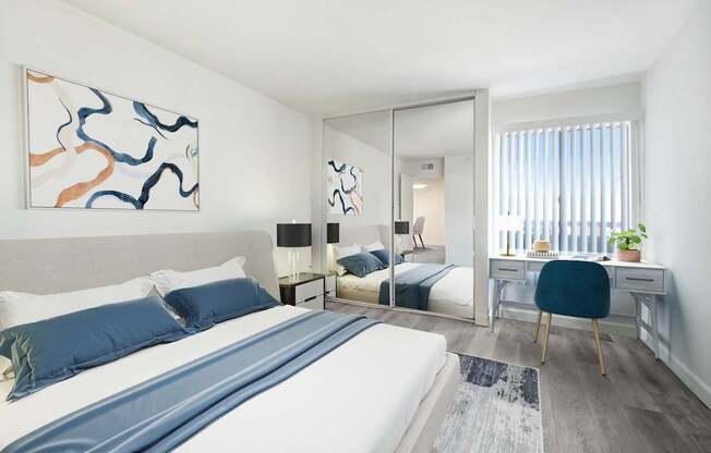 A bedroom with a large bed and a painting on the wall.