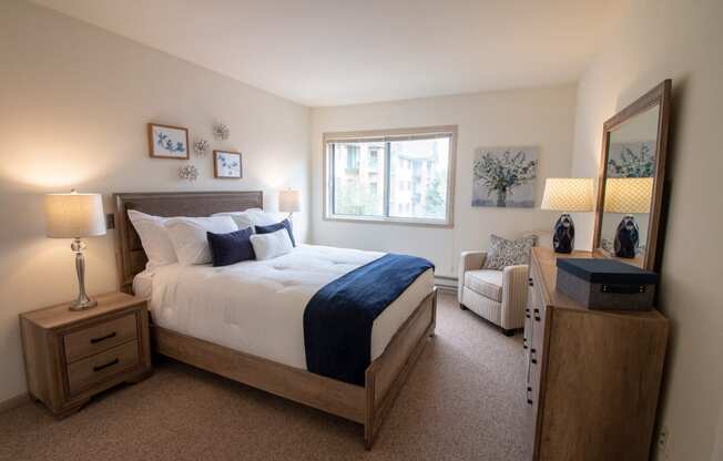 a bedroom with a bed and a chair and a window