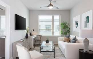 a living room with a white couch and a glass coffee table