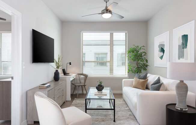 a living room with a white couch and a glass coffee table