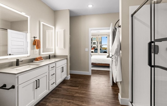 a bathroom with white cabinets and a shower and a sink