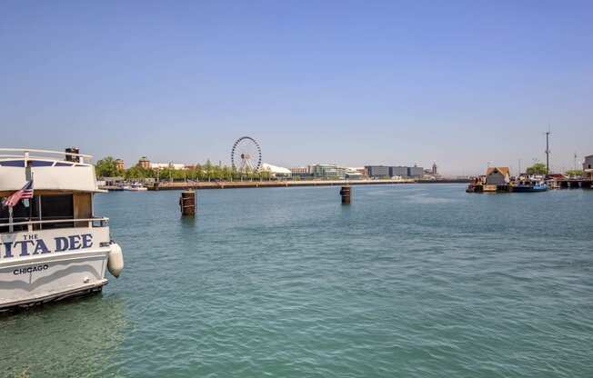 a boat in the water with a ferris wheel in the background at North Harbor Tower, Chicago, 60601