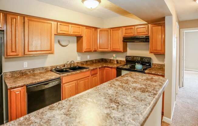 a kitchen with granite counter tops and wooden cabinets. Omaha, NE Evergreen Terrace Apartments