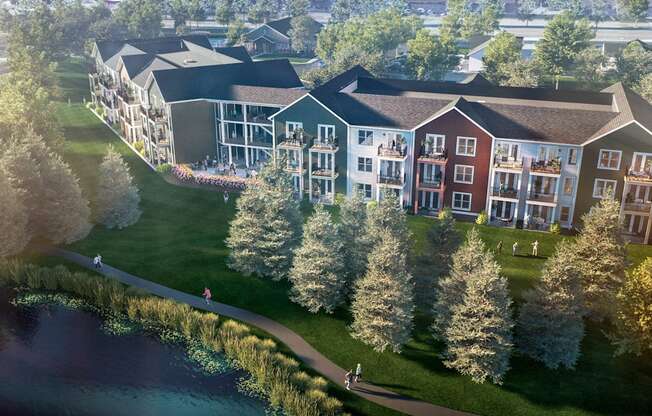 an aerial view of a building next to a body of water and trees
