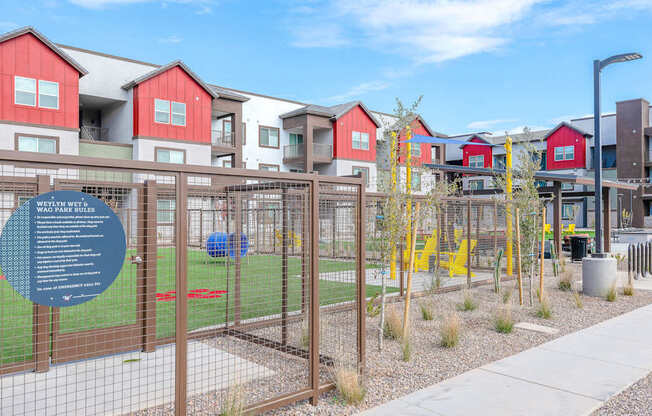 A sign in front of a fence with a blue background and white text.
