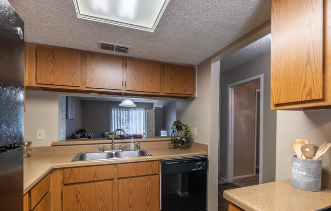 A kitchen with wooden cabinets and a stainless steel refrigerator.