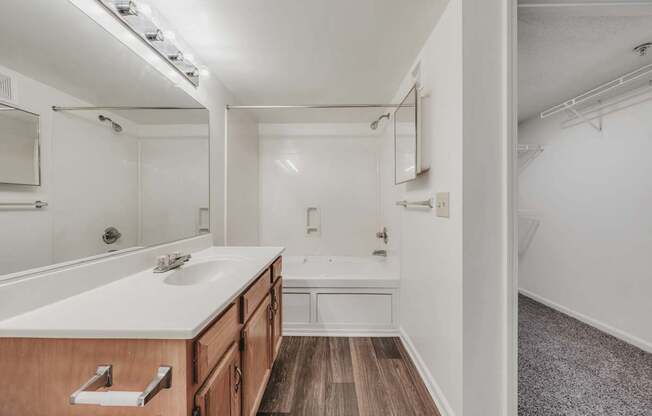 A bathroom with a wooden vanity and a white countertop.