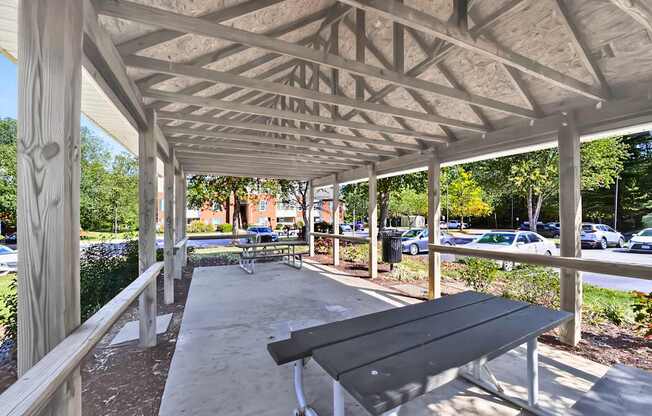 A wooden pavilion with a bench underneath it.