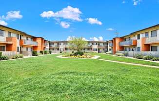 an exterior view of an apartment building with a grassy courtyard