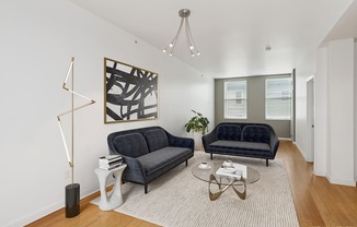 A living room with a black couch and a coffee table.