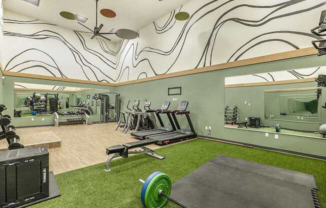 A gym with a green weight and a mirror on the wall.