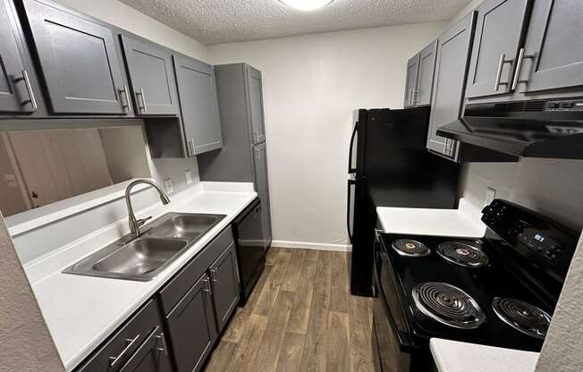 a kitchen with black appliances and white counter tops and a sink