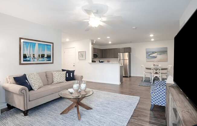A living room with a beige couch, a coffee table, and a painting on the wall.