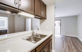 A kitchen with a sink and brown cabinets.