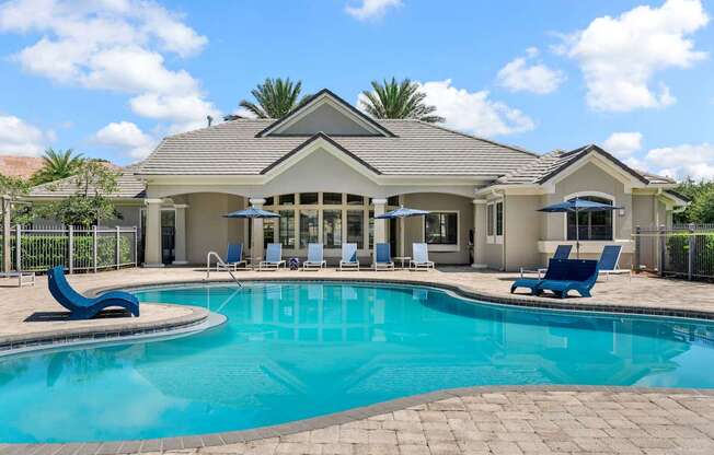 A house with a pool in front of it.
