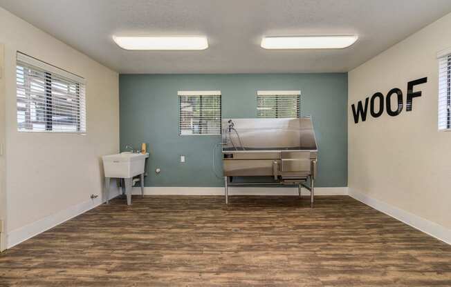 Dog Spa Tub with Hardwood Inspired Floor, Dog Washing Tub, WOOF Written in Black Letters on Wall, and Fluorescent Lights