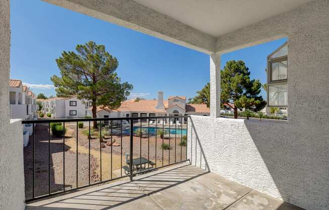 a balcony with a view of a pool and trees