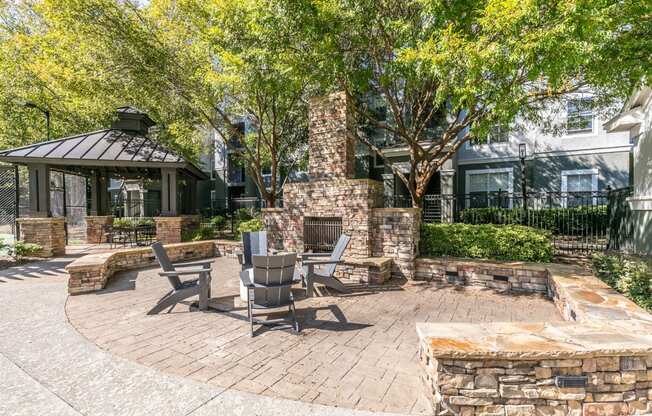 a patio with a stone fireplace and a table and chairs at Deerfield Village, Alpharetta, GA