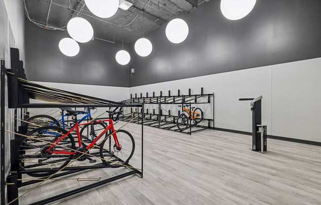 A room with a bicycle parking area and a white wall.