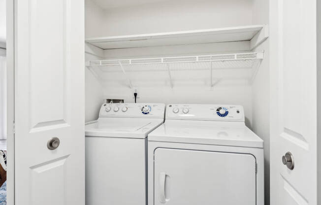 A white washing machine and dryer in a small laundry room.