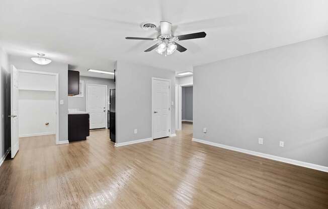 A room with a ceiling fan and wooden flooring.