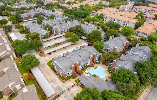 A bird's eye view of a residential area with houses and a swimming pool.