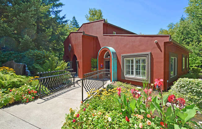 A red house with a garden in front.