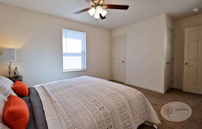 A bedroom with a large bed and a ceiling fan.