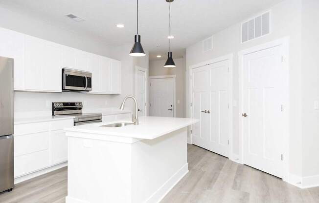 A white kitchen with a sink and a microwave.