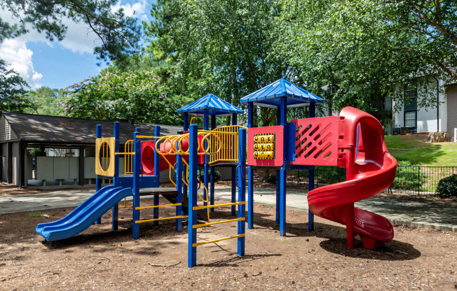 a playground with a swing set and slides at a parkat Glen Hollow, Decatur, Georgia