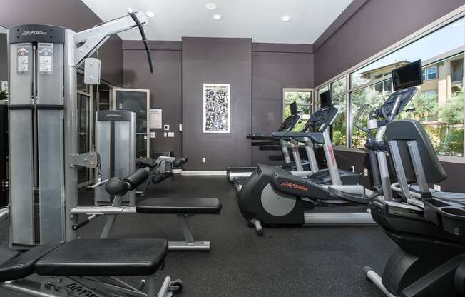 a room filled with lots of cardio equipment and weights