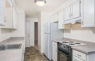 a kitchen with white cabinets and a stove and refrigerator