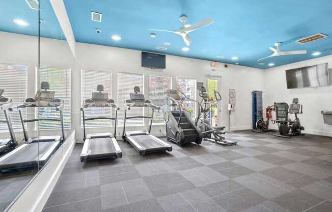 A gym with treadmills, elliptical machines, and other exercise equipment.