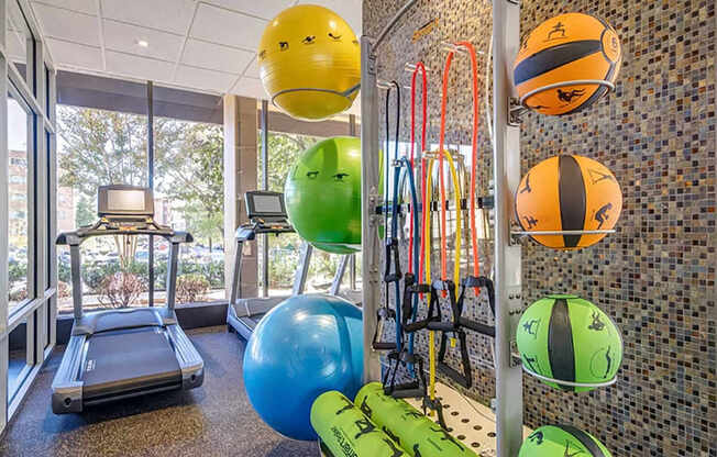 A gym with exercise balls and a treadmill.