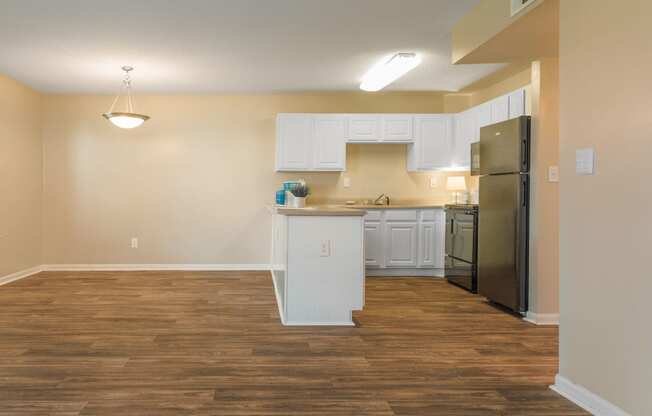 a kitchen and living room with a wooden floor