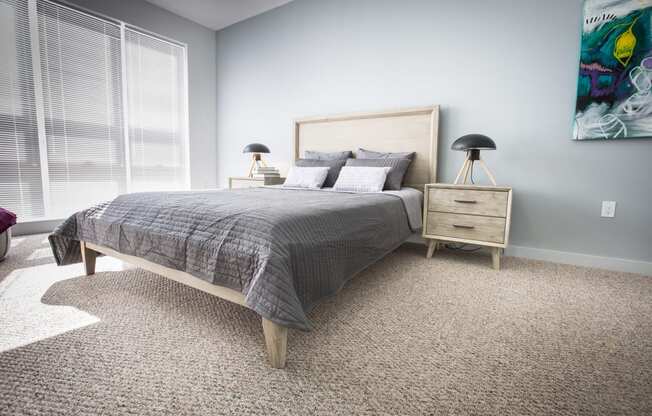 Bedroom model with carpeted floor and light wooden furniture