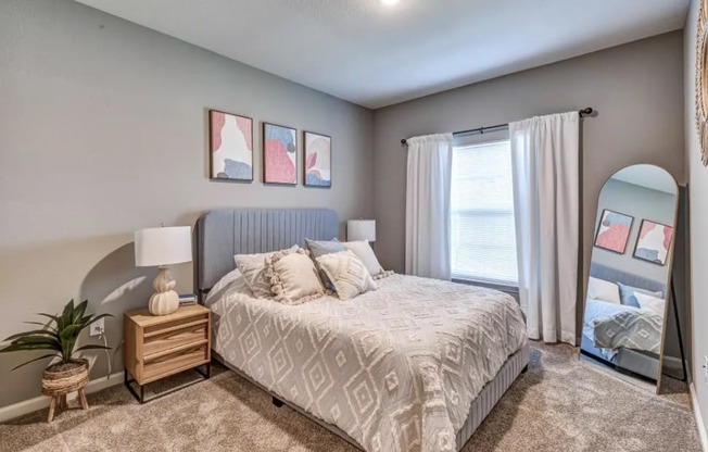 Bedroom with a large bed and a large window at Flats at Sundown apartments in North Port, Fl