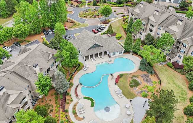 A bird's eye view of a residential area with apartments, and a swimming pool.