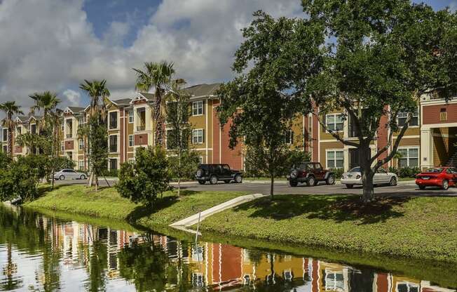 a city with a pond in front of a row of houses