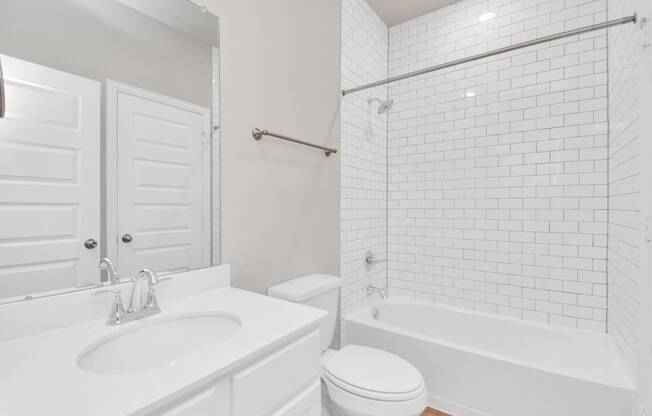 a bathroom with a white sink and toilet next to a bathtub with a shower curtain