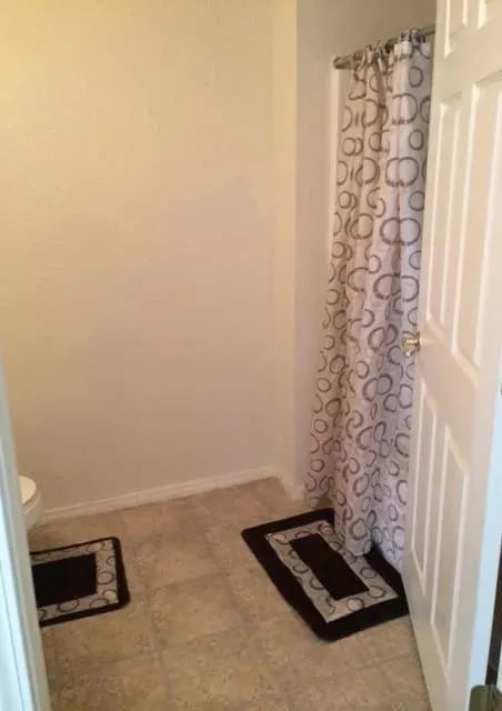 a bathroom with a toilet and a shower curtain at EDGEWOOD AT GABLES Apartments, TULSA, OK, 74127