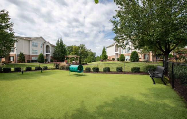 A green lawn in front of apartment buildings.