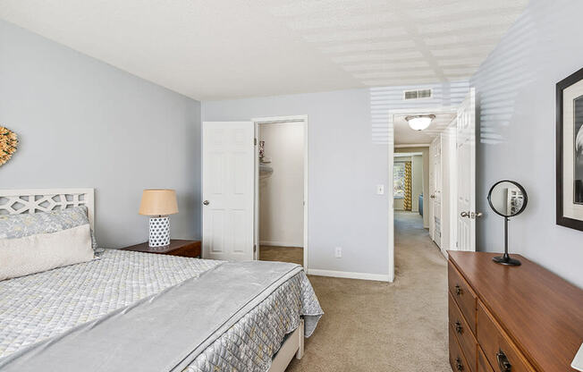 a bedroom with a bed and a dresser and a hallway