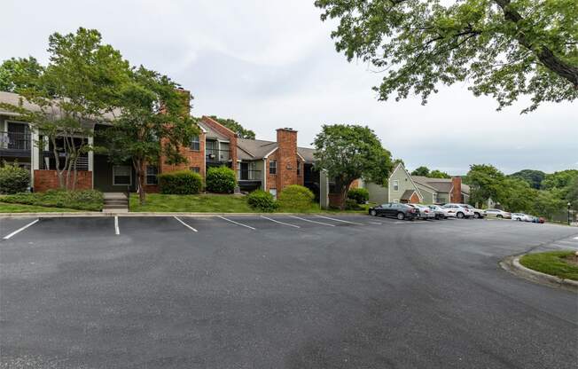 a parking lot in front of a row of apartment buildings