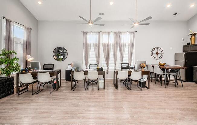 A well-lit room with a dining table and chairs, a desk with a computer, and a ceiling fan.