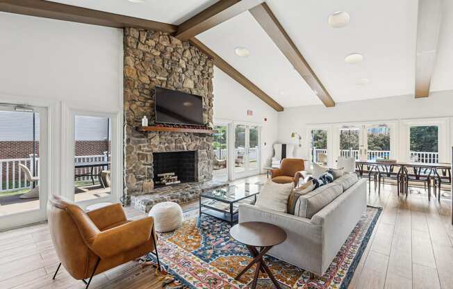 A living room with a stone fireplace and a television above it.