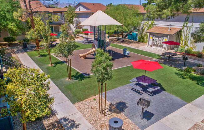 an aerial view of a park with trees and umbrellas